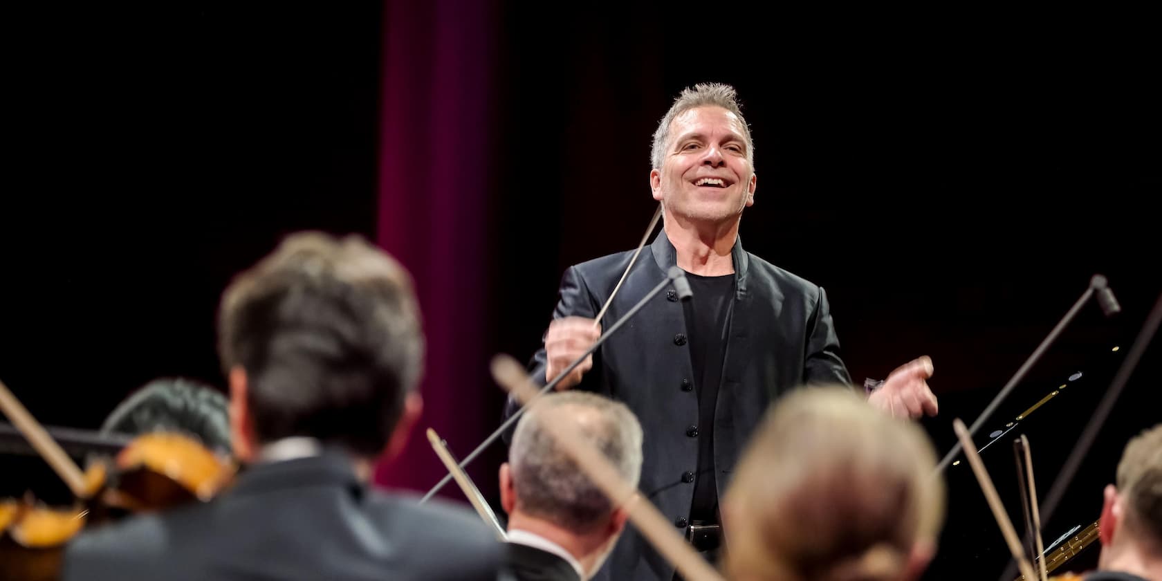 Ein Dirigent leitet ein Orchester während eines Konzerts.