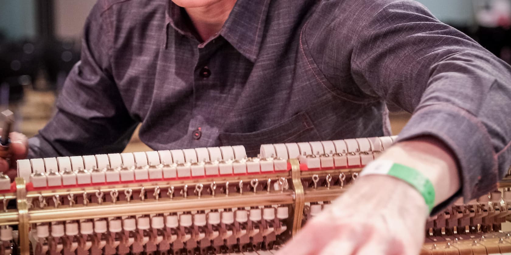 Eine Person, die an der Mechanik eines Klaviers arbeitet.
